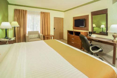 a hotel room with a large bed and a desk at Quality Inn Ciudad Obregon in Ciudad Obregón