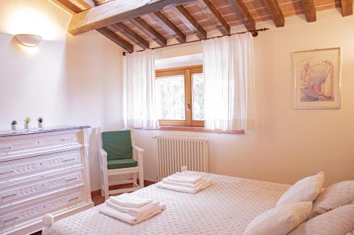 una camera con un letto e una sedia e una finestra di Casa VELIA 78Mq a 30 metri dal Mare di San Vincenzo a San Vincenzo