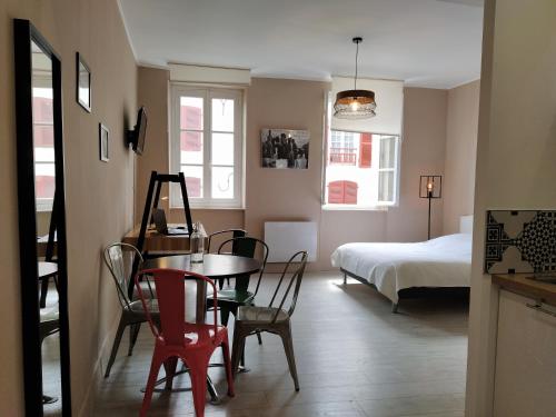 une pièce avec une table, des chaises et un lit dans l'établissement Baiona Sainte Cath -2-BI-, à Bayonne