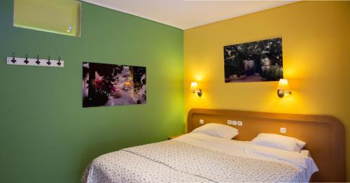 a bedroom with a bed and two pictures on the wall at Hotel Segas in Loutraki