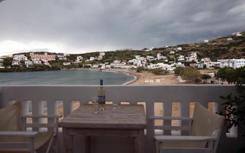 a table with a bottle of wine on a balcony with a beach at Bella Vista in Batsi