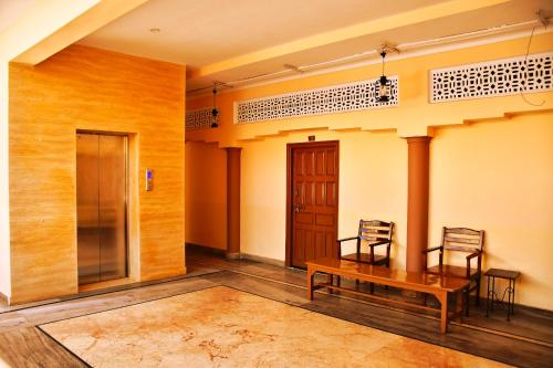 Pokój z 2 krzesłami i drewnianym stołem w obiekcie Gobind Bhawan Heritage Hotel w mieście Haridwar