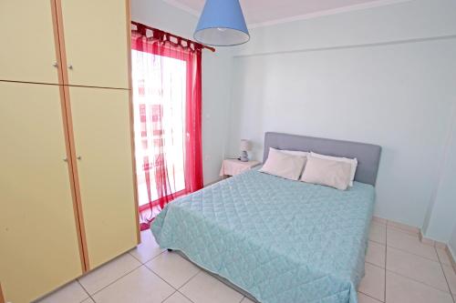 een slaapkamer met een bed en een groot raam bij Apartment near the sea and the Athens airport , Artemida in Artemida
