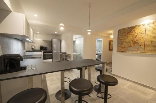 une cuisine avec un comptoir et des tabourets dans une pièce dans l'établissement LE PATIO D'ALÉSIA, à Paris
