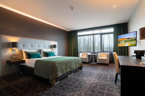 a hotel room with a bed and a desk at Van Der Valk Hotel Almere in Almere