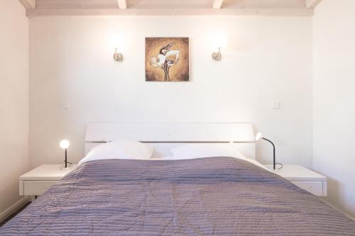 ダゲビュルにあるFerienhaus Föhrのベッドルーム1室(ベッド1台付)が備わります。壁には絵画が飾られています。