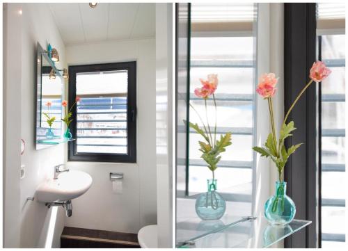 ein Badezimmer mit einem Waschbecken und einer Vase mit Blumen auf einem Glastisch in der Unterkunft fewo1846 - Floatinghouse - Hausboot mit 2 Schlafzimmern in der Marina Sonwik in Flensburg