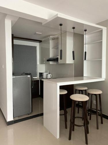 a kitchen with a counter and stools in it at Lake Infinity Luxury Condos in Nuwara Eliya