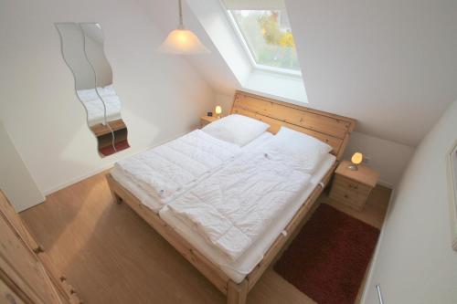 une chambre avec un lit avec des draps blancs et une fenêtre dans l'établissement 1006 - Haus Seesternweg, à Dahme