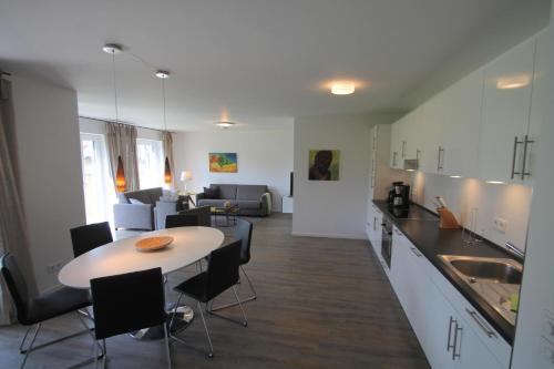 eine Küche und ein Wohnzimmer mit Tisch und Stühlen in der Unterkunft 1902 - Am Kurpark in Dahme