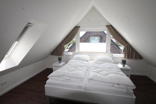 a bedroom with a white bed in a attic at 1380- Annina 3 in Dahme