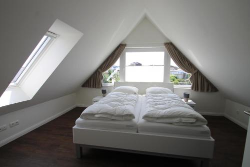 a bed in a room with two windows at 1360- Annina 1 in Dahme