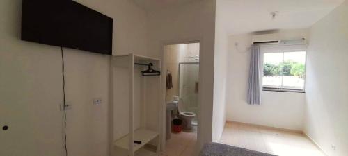 a bathroom with a shower and a toilet and a window at Pousada Pontal do Sul in Pontal do Paraná