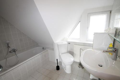 ein weißes Bad mit einem WC und einem Waschbecken in der Unterkunft 1000 - Lüntsches Schloss Riepsdorf in Thomsdorf