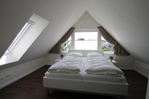 una cama en una habitación con dos ventanas en 1370- Annina 2, en Dahme