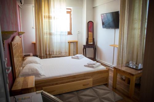 een slaapkamer met een bed en een tv. bij Hotel Funnytime in Boekarest