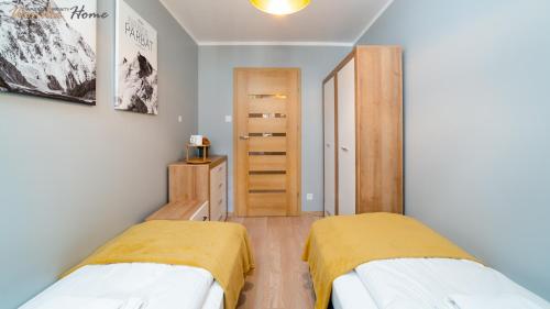 a bedroom with two beds and a closet at Wonder Home - Apartamenty położone blisko deptaka, licznych restauracji i sklepów in Karpacz