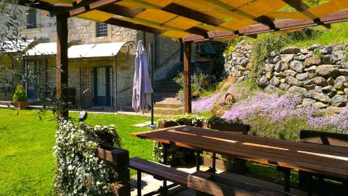 - un banc en bois dans un jardin avec un mur en pierre dans l'établissement Podere Pontepietra, à Soriano nel Cimino