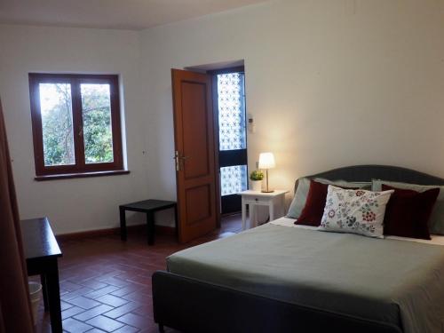 a bedroom with a bed and a door and windows at Casa Ulisse in Roccella Ionica