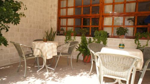 a patio with two tables and chairs and windows at Idi in Agia Galini