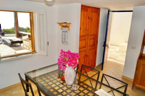 a table with a vase of flowers on it at Waterfront Villa in Pantelleria