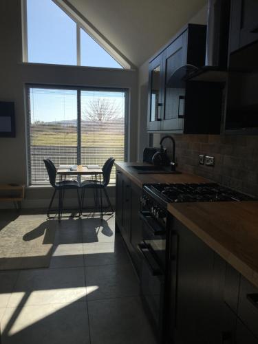 uma cozinha com mesa e cadeiras e uma janela em Braeside Bothy em Dunvegan