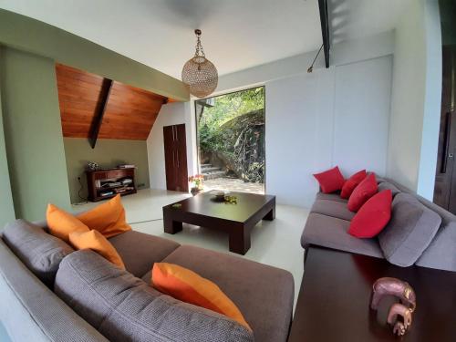 a living room with two couches and a table at GlenMyu Estate in Haputale