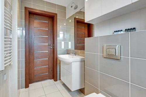 a small bathroom with a sink and a toilet at Dom & House - Apartamenty Sunrise in Sopot