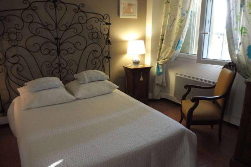 1 dormitorio con 1 cama, 2 sillas y ventana en Maison Provence à Baudinard-sur-Verdon, en Baudinard