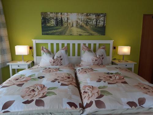 a bedroom with two beds with flowers on them at Garni-Hotel-Schäfer in Schuld
