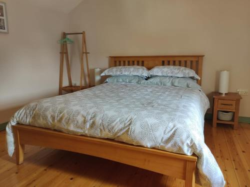 a bedroom with a bed with a wooden headboard and pillows at Alicias Cottage, Bacton in Norwich