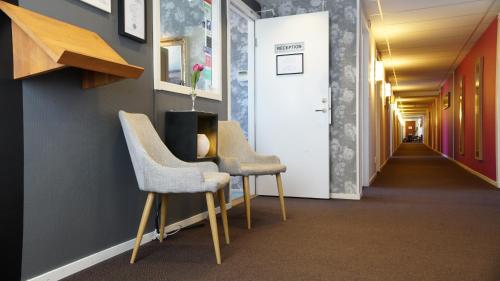 a corridor with two chairs and a hallway with a hallway at Le Mat B&B Göteborg City in Gothenburg