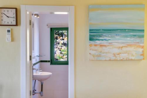 a bathroom with a sink and a window at Casa Uva in Yaiza