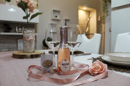 una bottiglia di vino seduta su un tavolo con bicchieri di CAMARDA SUITE a Bernalda