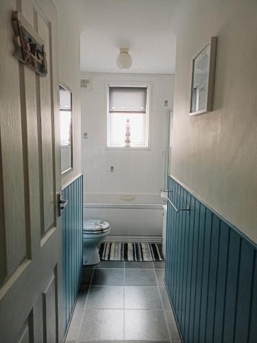 a bathroom with a toilet and a window at Esplanade Court Apartment with communal seasonal heated pool in Paignton