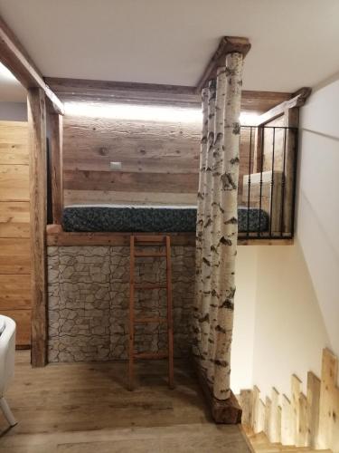 a bunk bed in a room with a stone wall at FIOCCO DI NEVE in Vezza dʼOglio