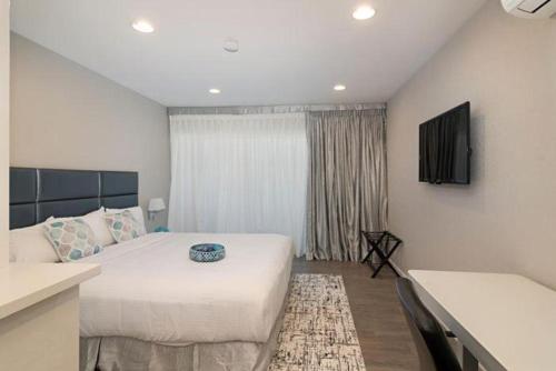 a bedroom with a bed and a table in a room at Sands Of La Jolla in San Diego