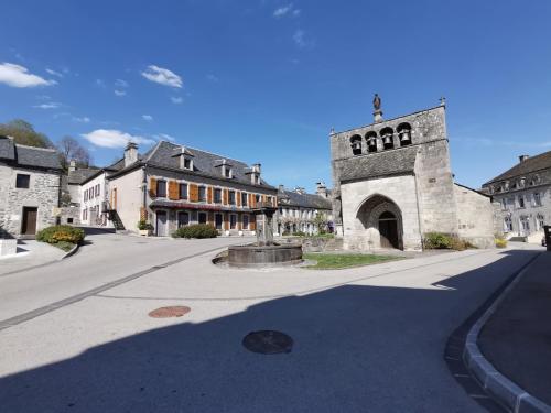 una calle vacía con un edificio con una torre de reloj en La Ruche Cantalienne en Saint-Étienne-de-Chomeil