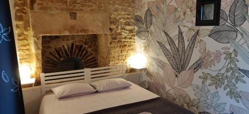 a bed with two pillows in a room with a wall at les 2 Gîtes du Clos de la Vigne in Montreuil