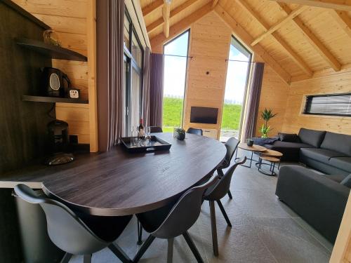 a living room with a large wooden table and chairs at Chalet met Sauna en Airconditioning in Sint Annaland