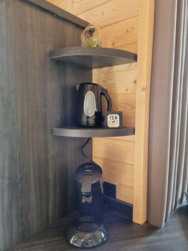 a coffee maker on a shelf in a room at Chalet met Sauna en Airconditioning in Sint Annaland