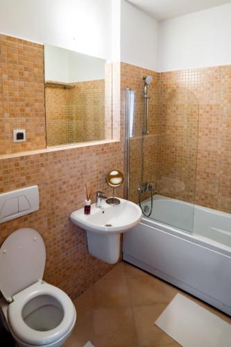a bathroom with a toilet and a sink and a tub at Elite Apartments Sinaia in Sinaia