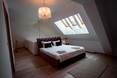 a small bedroom with a bed and a chandelier at Elite Apartments Sinaia in Sinaia