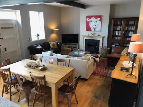 ein Wohnzimmer mit einem Sofa und einem Tisch in der Unterkunft Berkeley Coach House, near Bath in Bath