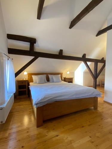 1 dormitorio con 1 cama grande con vigas de madera en Pension Wok, en Český Krumlov