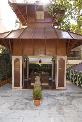 an outdoor patio with awning and a potted plant at Mayfair Darjeeling in Darjeeling