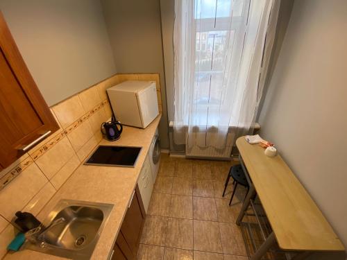 a small kitchen with a sink and a microwave at ApartHotel Riga in Rīga