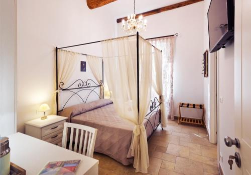 a bedroom with a canopy bed and a table at Casa Porta Marina in Ventimiglia