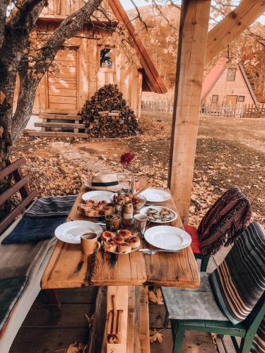 a wooden table with plates of food on it at Maple village in Žabljak