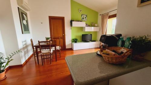 un soggiorno con pareti verdi e una cucina con tavolo di La Coccinella a Olbia